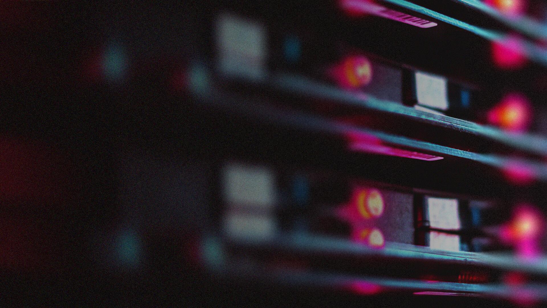 Close-up of colorful LED lights on a dark server rack, creating a futuristic and technological atmosphere.