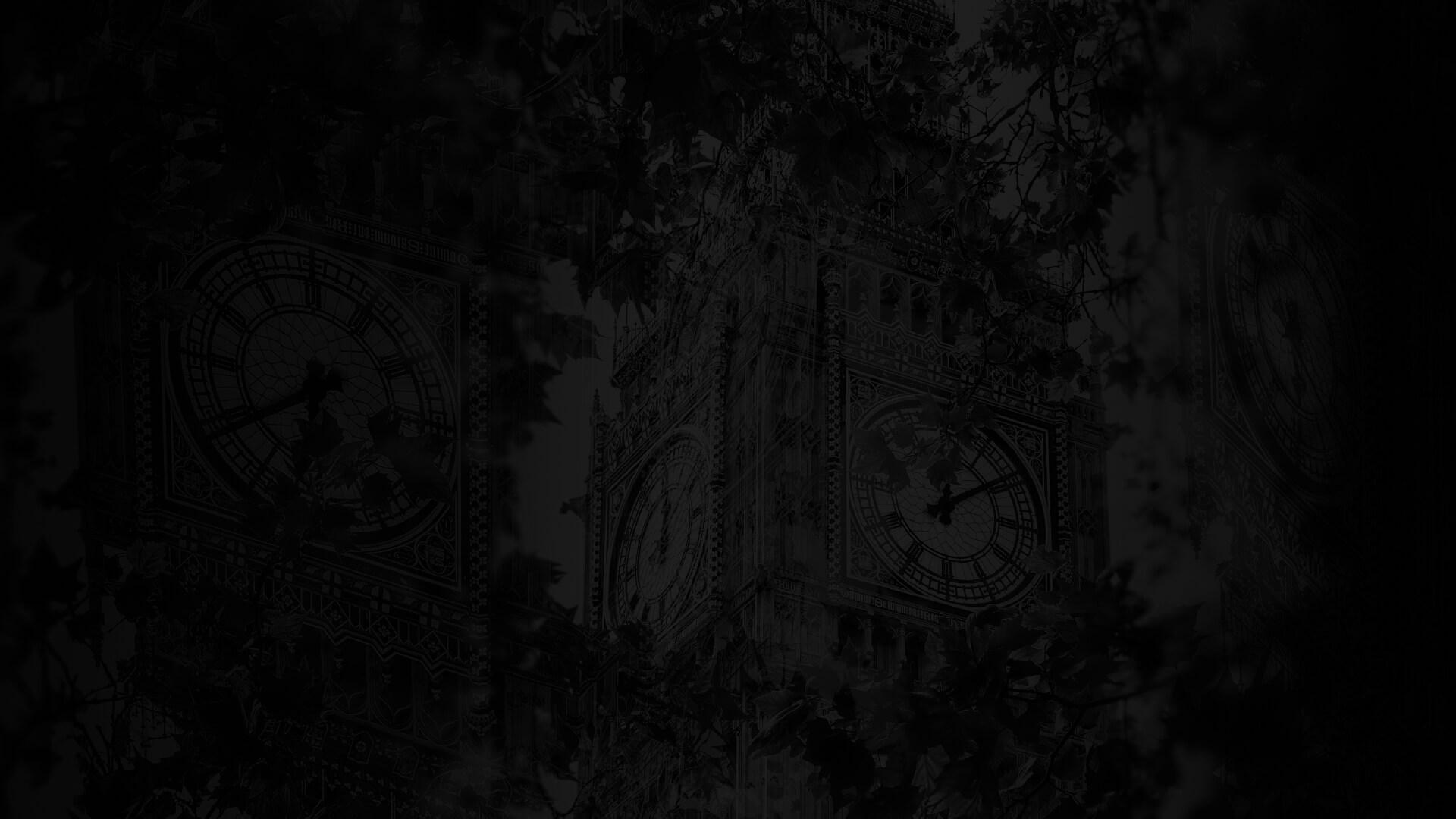A dimly lit image of a clock tower, partially obscured by tree branches, with intricate clock faces visible.