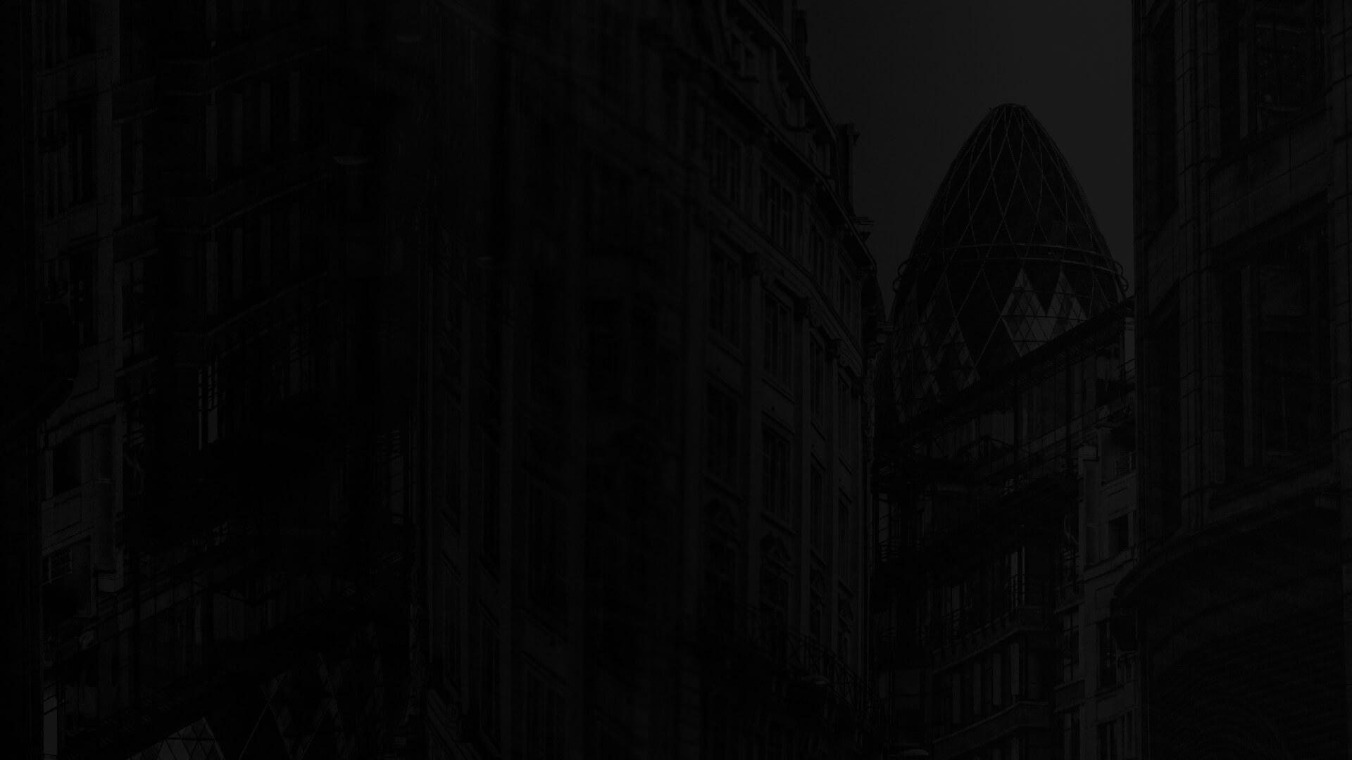 Dark cityscape featuring tall buildings and a distinctive, dome-shaped skyscraper in the background.